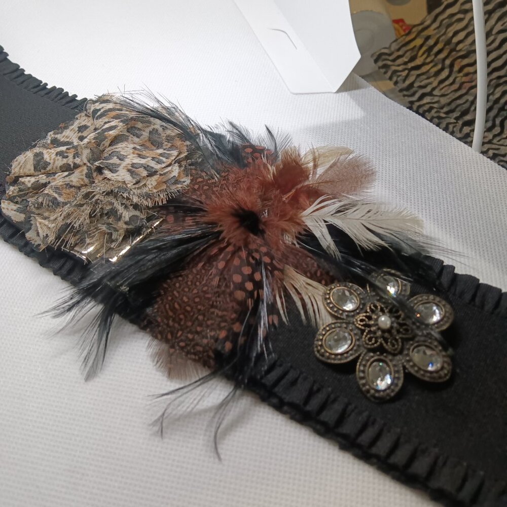 A hand made black stretch belt created in a rich wild animal motief.